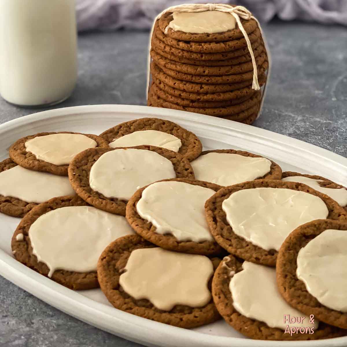 Frosted molasses cookies on a plate.