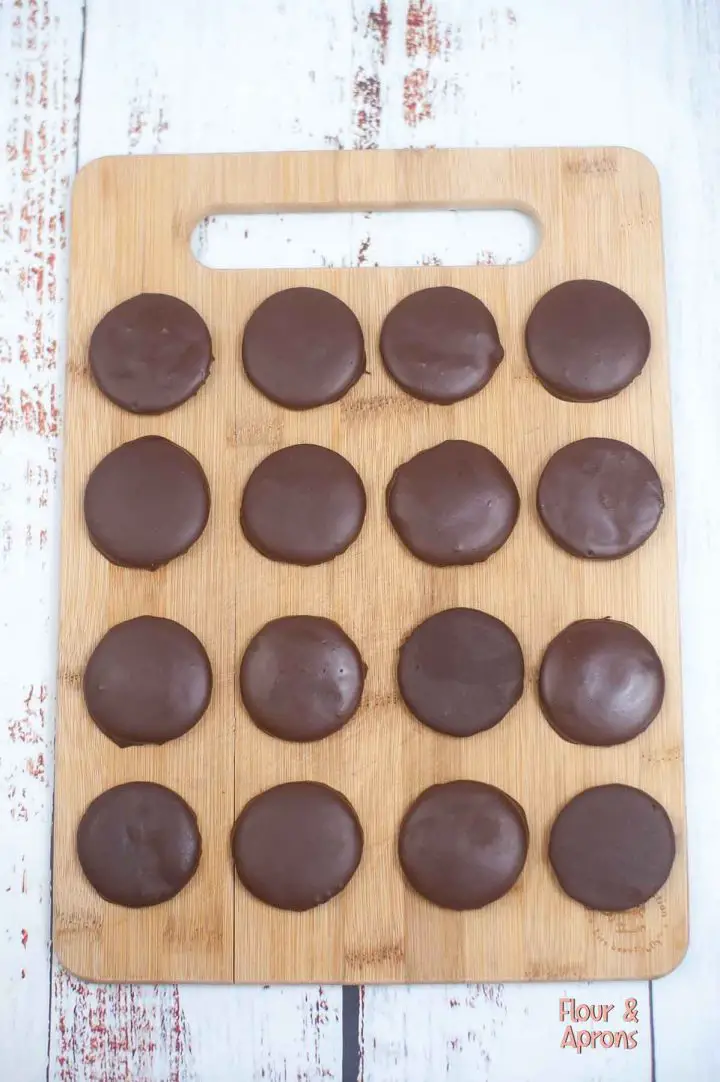 Chocolate covered cookies on a cutting board.