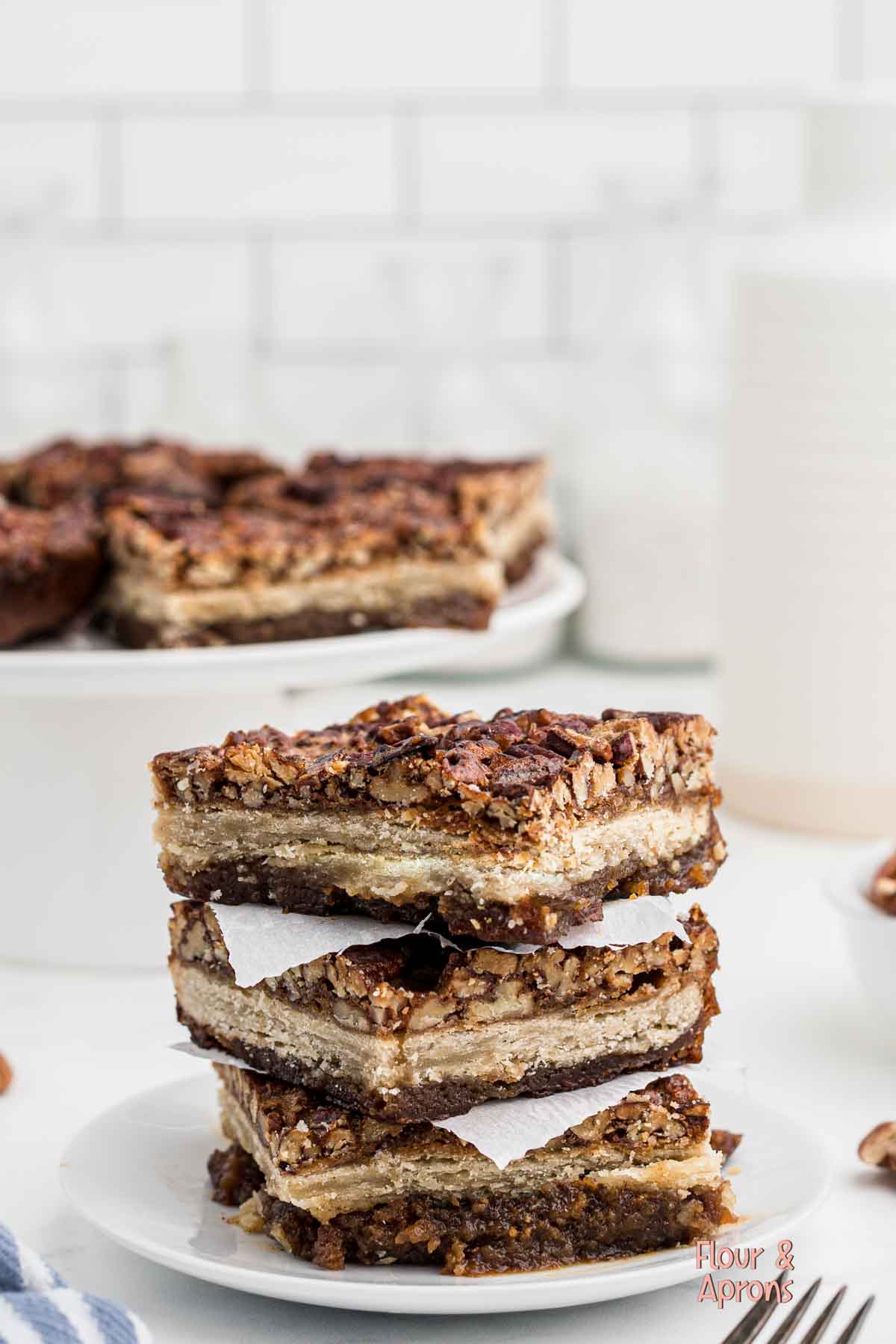 Pecan pie bars stacked on a plate.