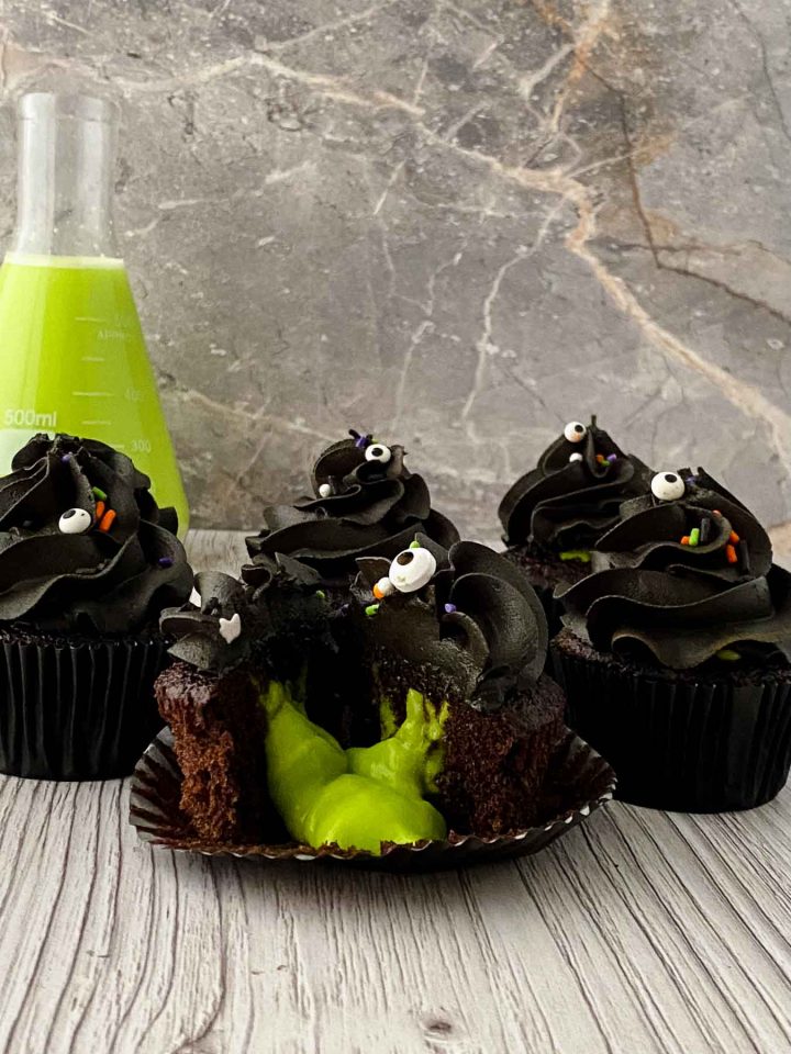 3 slime cupcakes, front one is cut open with green slime oozing out.