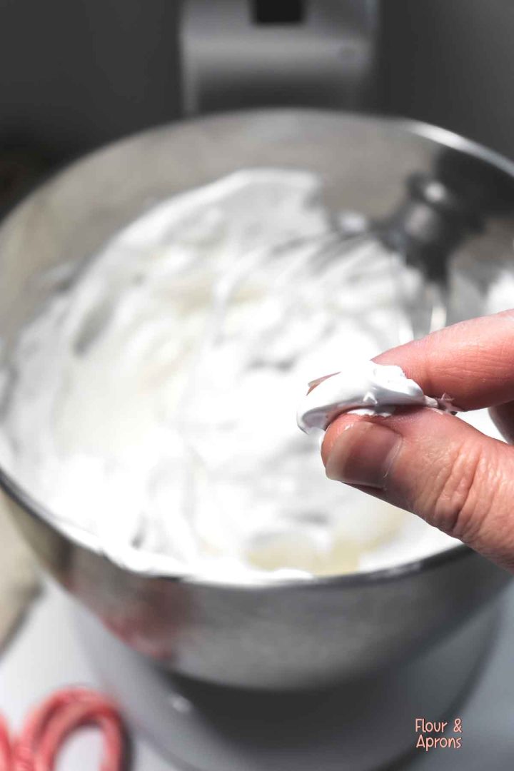 Testing meringue between fingers.