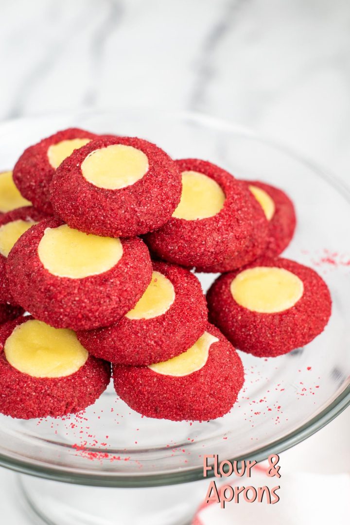 Red velvet thumbprint cookies on a plate.
