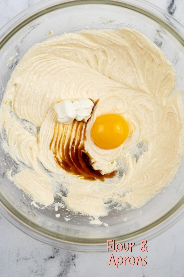 Egg yolk, vanilla and sour cream added to mix of cream cheese & sugar.